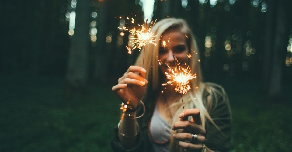 Vrouw met sterretjes in haar handen straalt plezier uit – symbool voor het vieren van kleine en grote successen.